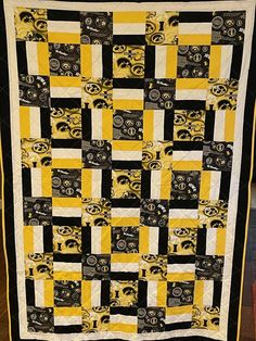 a black and yellow quilt with eyes on it