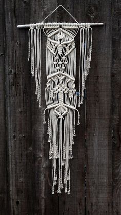 a white macrame hanging on a wooden fence