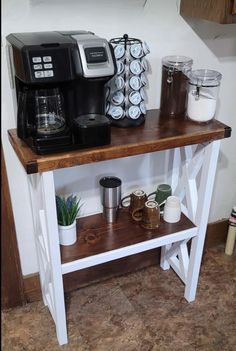 a coffee maker and some cups on a table