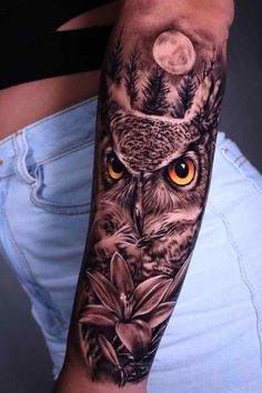 an owl tattoo on the arm with yellow eyes and leaves around it's head