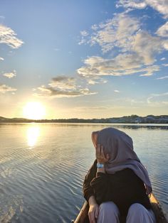 a woman sitting on top of a boat in the water