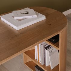 two books are sitting on top of a book shelf next to a coffee table with several books