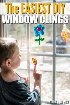 a young boy is looking out the window and holding a pinwheel in his hand