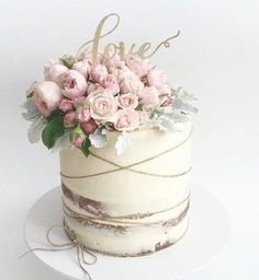 a white cake with pink flowers and the word love on top