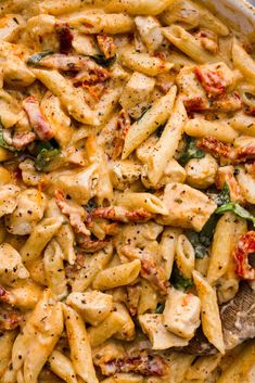 pasta with chicken and spinach in a white bowl