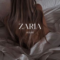 a woman laying on top of a bed covered in white sheets with the word zaria over her head