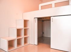 an empty room with shelves and a white door