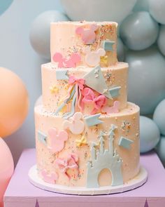 a three tiered cake is decorated with pastel colors