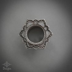 an ornate silver ring on a gray background with the word,'s name written below it