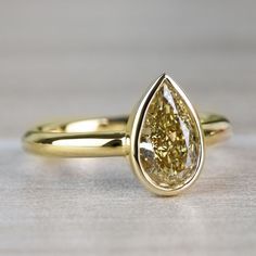 a yellow diamond ring sitting on top of a table