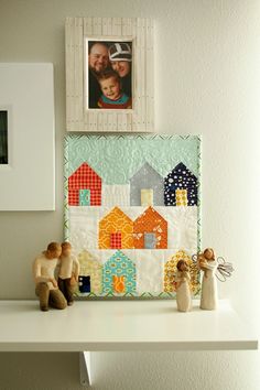 a couple of figurines sitting on top of a white shelf next to a picture