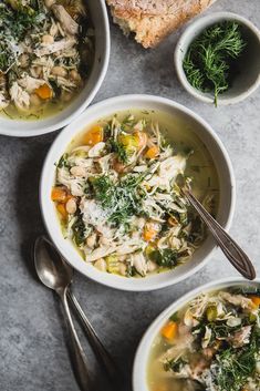 three bowls of chicken and vegetable soup on a table