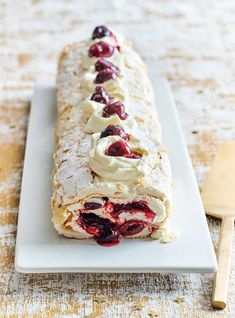 a long pastry with cream and cherries on it