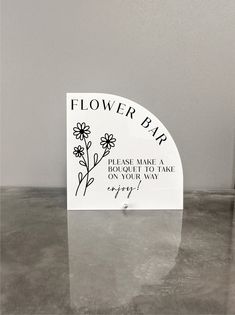 a flower bar sign sitting on top of a table