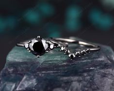 two black and white diamond rings on top of a rock