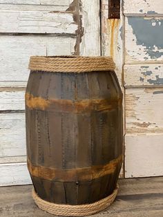 a wooden barrel sitting on top of a hard wood floor next to a white door