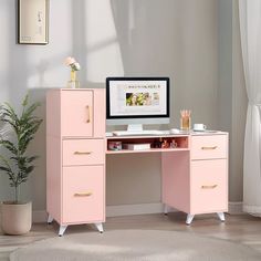 a pink desk with drawers and a computer monitor