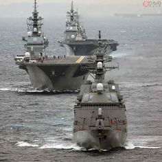 two navy ships in the water near each other