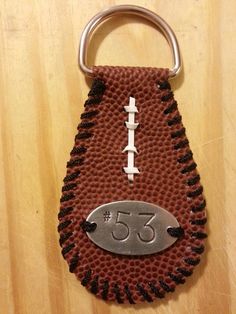 a football keychain with the number 55 on it and an iron plate in the shape of a football