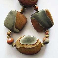 "This exotic and distinctive necklace has all the eye-catching characteristics of genuine Polychrome Desert Stones: Naturally vibrant earthy colors in landscape-like spheres of beautiful gray-greens and terra-cotta reds, tans and browns. This necklace truly unique - as intriguing as each of each of its rare Madagascar Desert Jasper stones.  No two stone are alike. Photos show both sides of each stone.  Miriam's designs are one-of-a-kind creations that epitomize the fashion expression \"wearable Unique Multicolor Jasper Jewelry, Earthy Jasper Round Bead Jewelry, Artisan Brown Necklace With Large Stone, Unique Jasper Jewelry With Polished Beads, Multicolor Jasper Gemstone Beads Jewelry, Unique Multicolor Jasper Necklaces, Earthy Jasper Beaded Necklace With Gemstone Beads, Artisan Jasper Necklace With Large Stone, Ocean Jasper Necklace