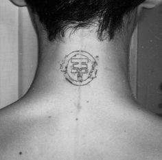 the back of a man's neck with a small tattoo on his left side