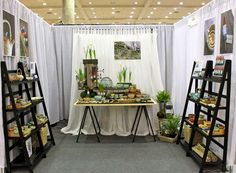 a room filled with lots of different types of food and plants on display in front of a white curtain