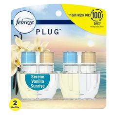 three bottles of water with flowers on the beach in front of an advertisement for febreze