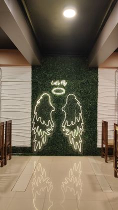 two angel wings are projected on the wall next to each other in front of chairs