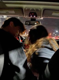 two people sitting in the back seat of a car