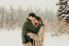 a man and woman are hugging in the snow