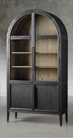 an arched wooden cabinet with shelves and doors