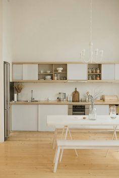 a kitchen with white walls and wooden floors