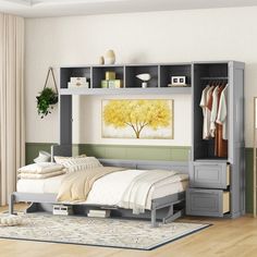 a bed sitting under a shelf next to a wall mounted cabinet with clothes on it