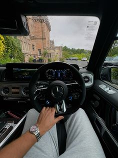 a man driving a car with his hands on the steering wheel