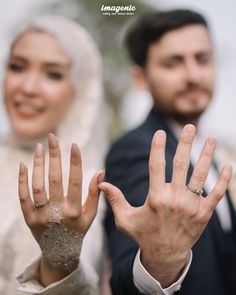 a man and woman with their hands in the air