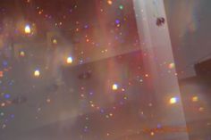 blurry image of colorful lights on the ceiling in a room with white walls and flooring