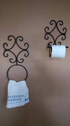 two towel racks are hanging on the wall next to toilet paper rolls in a bathroom