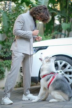 a man in a suit standing next to a dog