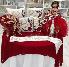 a red and white table topped with pillows and doll sitting on it's back