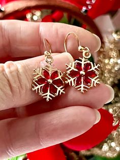 These gold charm earrings are so festive! They feature a red faceted glass poinsettia flower design atop a snowflake. The charms are metal alloy and they hang on gold plated ear wires. The drop is three quarters of an inch. Please scroll the photos for close ups and a visual guide to the size. These Holiday sparkle snowflake drops come packaged in a gift bag ready for gift giving. Holiday Happy Dance is a festive and fun jewelry collection that celebrates holidays and occasions throughout the ye Red Sparkle, Snowflake Earrings, Poinsettia Flower, Holiday Sparkle, Holiday Earring, Donate To Charity, Faceted Glass, Gold Charm, Poinsettia