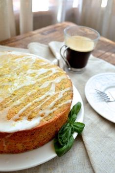 a cake sitting on top of a white plate next to a cup and saucer