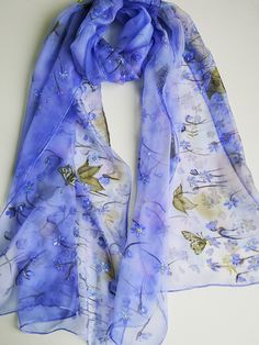 Hand painted charming silk chiffon scarf - Hepatica flowers. Alluring Blue-violet small Spring flowers blossoming all length long of this scarf. Few spring butterflies accompany this nature beauty. In Lithuanian language we call this flower 'Zibuokle'- that who sparkle , twinkle :) Truly these flowers seem shine in early spring on last autumn leaves ground . And So this painting was inspired :) Chiffon is very light and transparent silk fabric. It is transparent in one layer and rich colors are Purple Bohemian Scarves With Floral Print, Purple Silk Scarves For Spring, Purple Silk Scarf With Floral Print For Spring, Purple Floral Print Silk Scarf For Spring, Spring Wraps, Spring Shawl, Silk Chiffon Scarves, Chiffon Scarf, Blue Violet