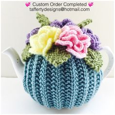 a knitted tea cosy with flowers on it