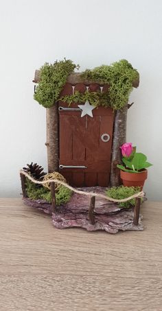 a small wooden door with moss growing on it's sides and a potted plant next to it