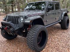 a gray jeep parked on top of a gravel field