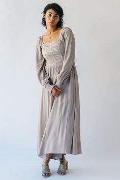 Indulge in the playful yet elegant Zwirner Ruched Bodice Maxi Dress! With its whimsical ruched bodice and flowy silhouette, this taupe dress is the perfect addition to your wardrobe. Stand out at any event with this versatile, charming dress. (It's the perfect mix of quirk and sophistication!) Details self/lining: 100% rayon Fabric Care Guide Here Sizing & Fit Measurements are approximate and taken while laying flat across the front. Not doubled. small: bust = 13.5"; length = 51" medium: bust = Flowy Midi Dress With Ruched Bodice, Flowy Ruched Maxi Dress With Square Neck, Elegant Smocked Dress With Gathered Sleeves, Flowy Square Neck Ruched Maxi Dress, Elegant Smocked Dress With Billowy Gathered Sleeves, Elegant Dresses With Gathered Sleeves For Gatherings, Elegant Long Sleeve Dress For Gatherings, Chic Beige Ruched Smocked Dress, Elegant Beige Smocked Dress