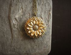 Detailed antique brass sunflower set on detailed antique brass filigree on an antique brass locket. Chain is antique brass. Locket opens with two spaces. Details: Locket measures 32mm in diameter Chain measures 24 inches Locket and chain are plated brass Lead and nickel free Thank you for shopping Delicate Industry :) Antique Gold Medallion Jewelry For Gift, Handmade Antique Gold Jewelry For Gifts, Antique Gold Jewelry Gift, Antique Gold Pendant Jewelry As Gift, Antique Gold Metal Jewelry Gift, Victorian Bronze Jewelry Gift, Antique Gold Metal Jewelry As A Gift, Antique Gold Metal Jewelry As Gift, Victorian Bronze Jewelry For Gift