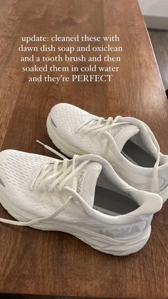 a pair of white shoes sitting on top of a wooden table