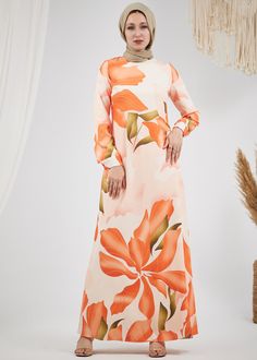 Step into elegance with our Radiant Floral Satin Maxi Dress. This stunning piece features a captivating floral pattern in vibrant hues of orange and green, making it a perfect choice for any special occasion. Crafted from luxurious satin, the dress is fully lined for comfort and modesty. The design includes long, subtly flared sleeves and a chic high neck, adding a touch of sophistication to your look. The dress is beautifully tailored with a matching belt that cinches the waist, creating a flat Orange Floral Print Maxi Dress For Garden Party, Orange Floral Maxi Dress For Garden Party, Elegant Orange Printed Maxi Dress, Orange Floral Print Long Sleeve Maxi Dress, Orange Maxi Dress For Spring Wedding, Orange Long Sleeve Maxi Dress For Garden Party, Orange Long Sleeve Printed Maxi Dress, Spring Wedding Orange Maxi Dress, Orange Long-sleeved Maxi Dress For Garden Party