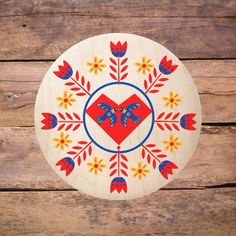 a wooden plate with an image of a heart and flowers in the center on a wood background